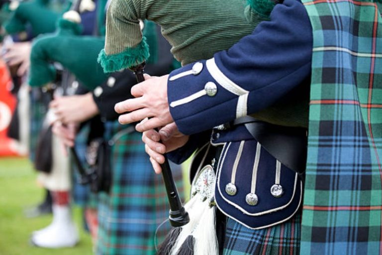 Musicien jouant en Ecosse avec le traditionnel kilt vert et bleu