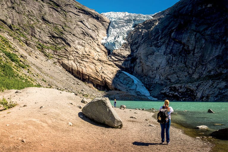 Randonnée Bergen : Touristes face à une falaise à coté d'un lac de montagne