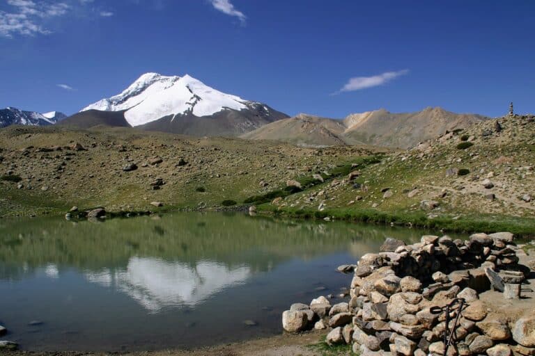 Randonnée en Inde himalayenne : un paysage montagneux enneigé, avec des collines, et un lac Akaoka