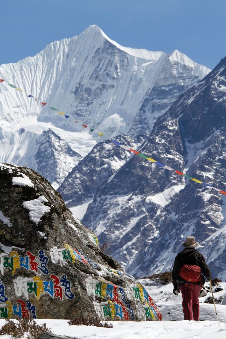 Randonnée au Népal dans les montagnes enneigées avec des drapeaux de prières Akaoka