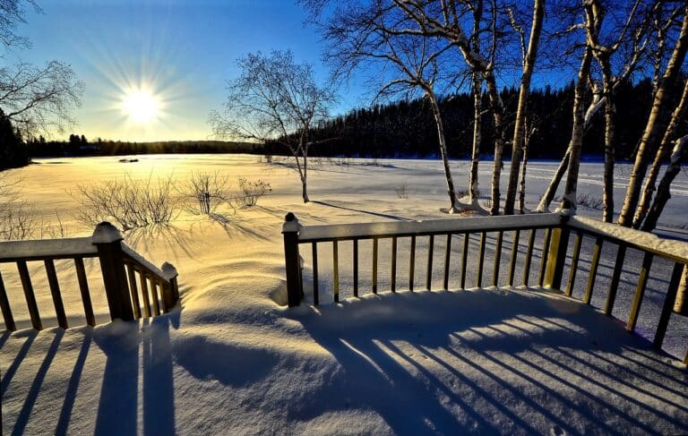 Voyage au Canada : terrasse d'une maison enneigée sous un coucher de soleil Akaoka