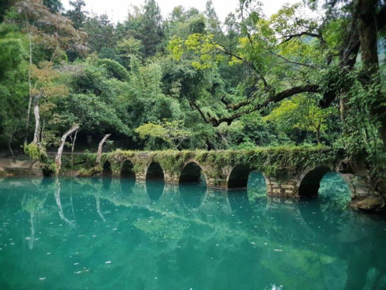 Randonnée Chine en forêt avec un pont en brique sur un lac vert Akaoka