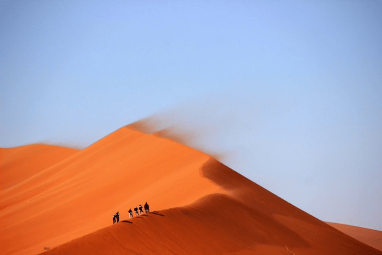 Trek Oman : Randonnée dans le désert aux couleurs orangées sous un magnifique ciel bleu