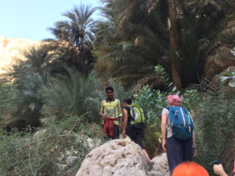 Excursions Oman : des randonneurs et un habitant sur Jebel Akhdar à Oman, au milieu de palmiers.