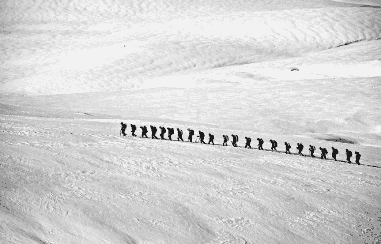 Raids-alpi groupe de randonneurs qui marche vers les montagnes avec plein de neige