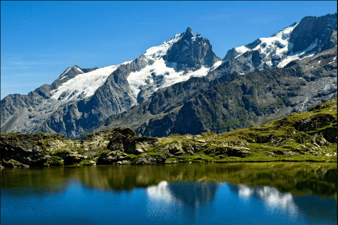 Paysage composé de d'un lac verdoyant surplombé de montagnes,tour des Ecrins