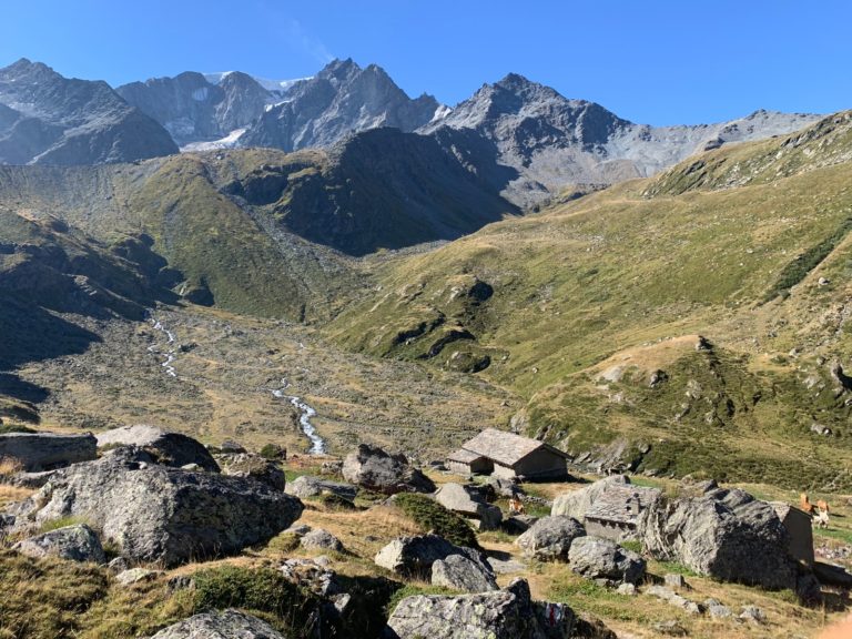 Trekking en suisse vue sur des rochers et cabane au pied des rochers et des montagnes en horizon